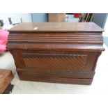 An antique Singer sewing machine with a carved wooden cover