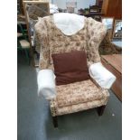 A George III style wingback armchair, button backed, in floral fabric,
