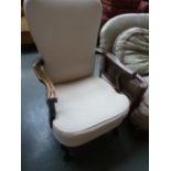 A 20th century mahogany open armchair, in cream upholstery,