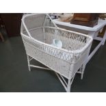 A white painted wicker basinet with floral liner,