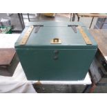 A green painted wooden storage box with brass straps,
