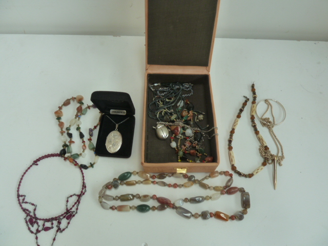 A box of jewellery to include a silver necklace, a coral necklace, a ladybird watch necklace,