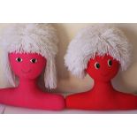 A pair of vintage stuffed children's clothes hangers in the form of a red boy with mop hair and a