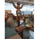 A Victorian walnut hall stand, with four pierced arms above a glove box and umbrella stand base,