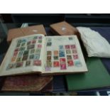 A selection of three stamp albums, two boxes of stamps and a packet of loose stamps,