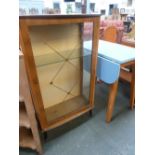 An Art Deco walnut display cabinet, side panels, raised on splayed feet,