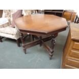 An octagonal mahogany table, on turned legs, carved X stretcher,