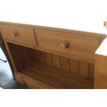 A modern pine side board with scrolling gallery over two short drawers open base 102cmW x 35cmD x