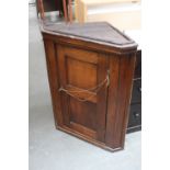 A Georgian oak corner cupboard with panelled door, replacement lock,