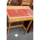 A child's school desk with a red painted lid