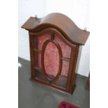 A modern hanging display cabinet with arched pediment