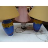 A pair of What's Vincent Cadeaux colourful bedside lamps with another floral lamp with pink shade