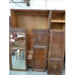 An early 20th century oak wardrobe, three doors, one mirrored over two long drawers,