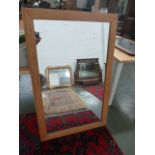 A large modern rectangular mirror with wooden frame