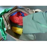 A canvas holdall containing a variety of over trousers and waterproofs suitable for boats and