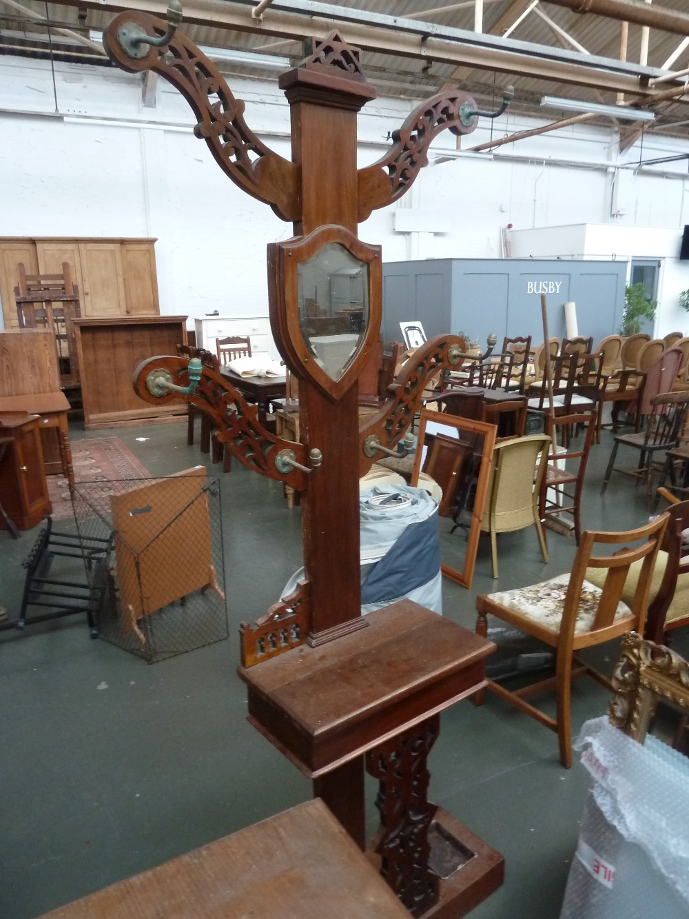 A Victorian walnut hall stand, with four pierced arms above a glove box and umbrella stand base,