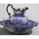 A china washbowl and jug of blue floral design with frilled edging heightened in gilt over a cream