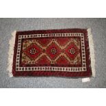 Two Eastern wool rugs, with stylised floral and and animal decoration on predominately red ground,