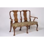 A walnut double chair back settee, in the George II manner, having scrolled arms,