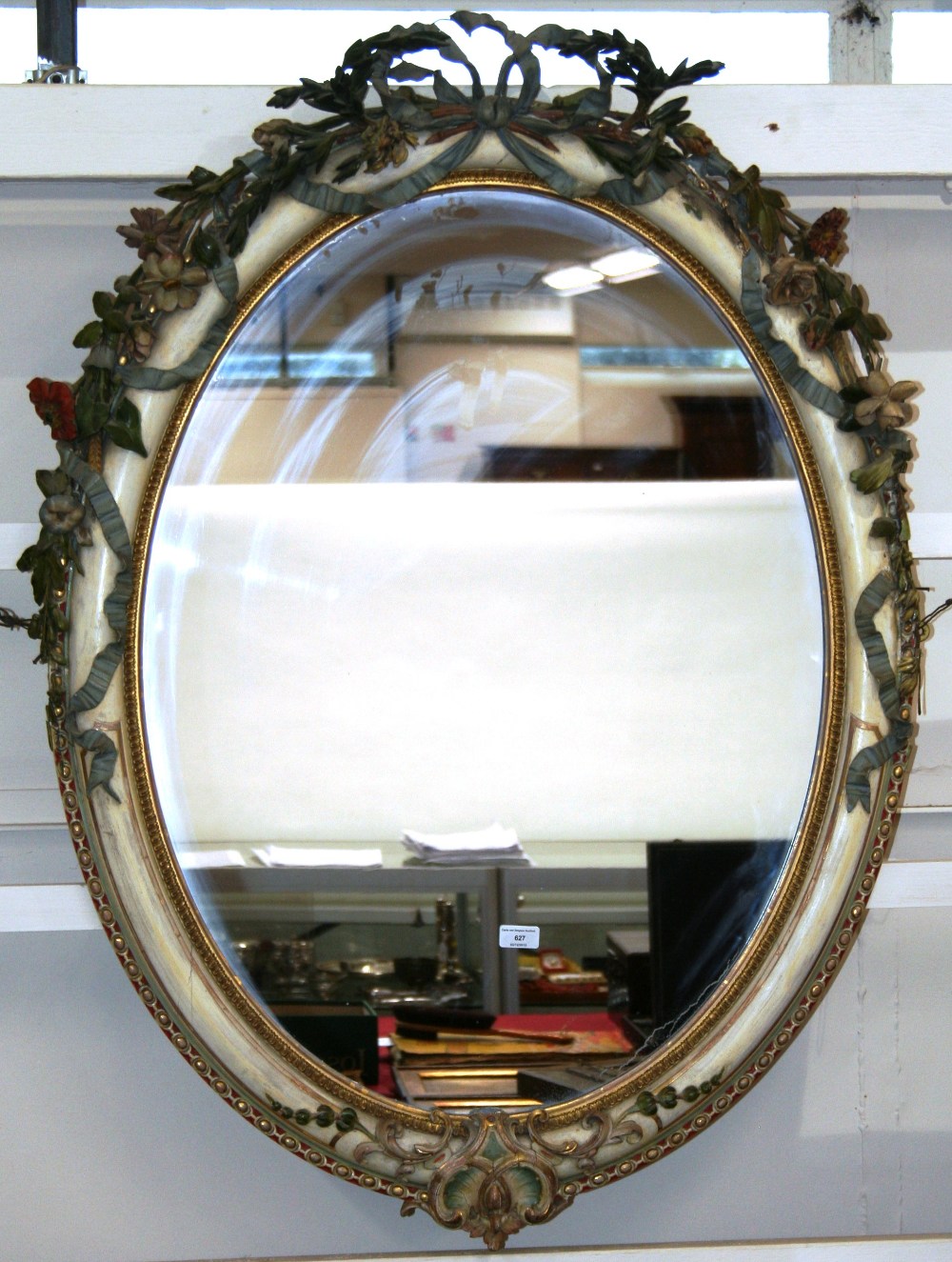 A 19th Century oval painted wall mirror, with foliate and ribbon tied applied decoration,