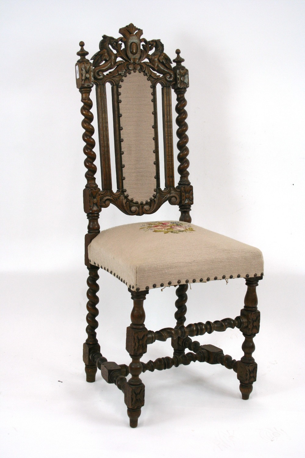 A Victorian oak hall chair, with carved beast and leaf decoration above spiral columns,