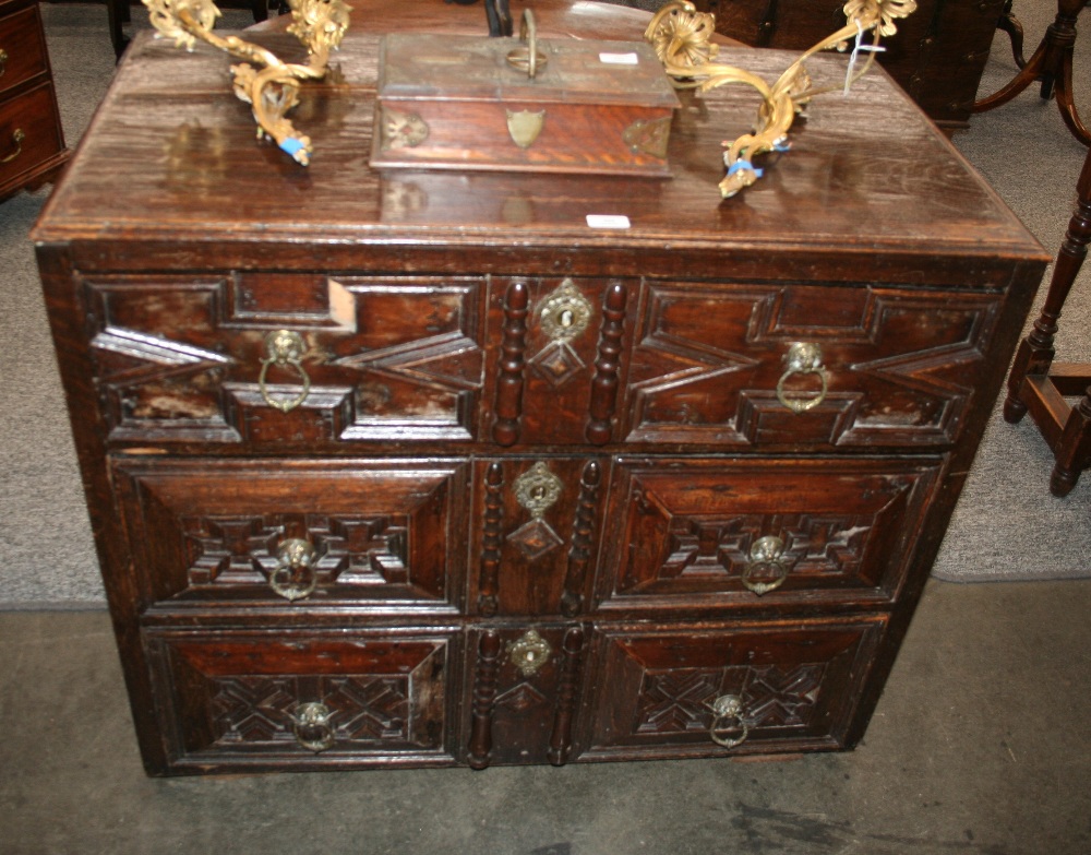 An Antique oak chest, the moulded top above three long graduated and geometrically moulded drawers,