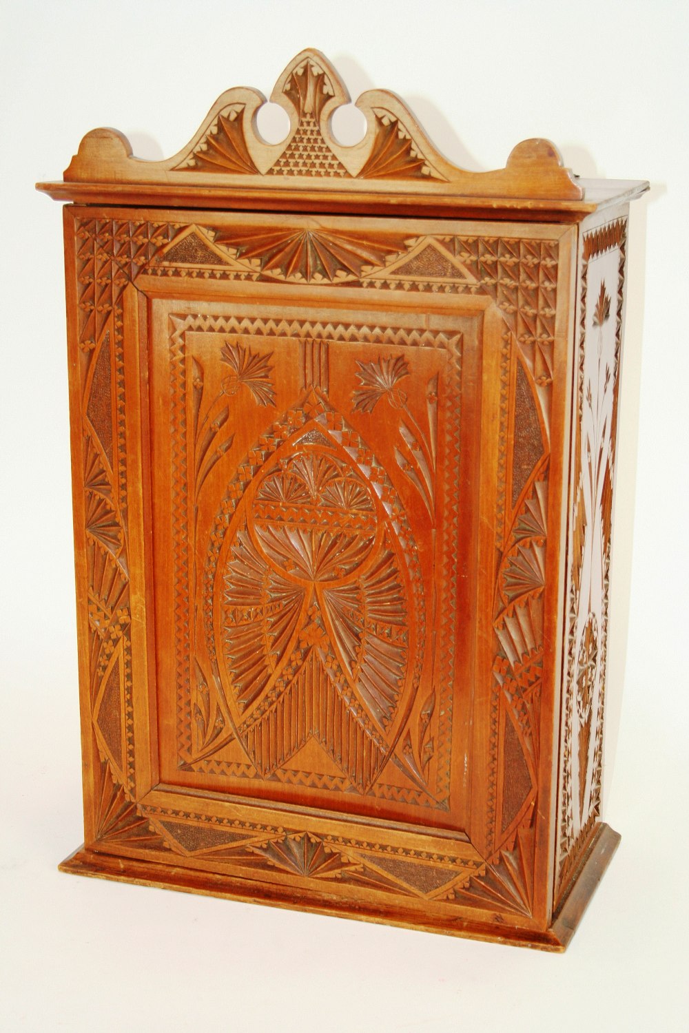 A 19th Century continental carved fruitwood wall cabinet, surmounted by a shaped pediment,