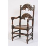An 18th Century oak Derbyshire type elbow chair, having carved back rail, solid seat,