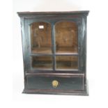An 18th Century pine wall cupboard, the interior shelves enclosed by a glazed panelled door,