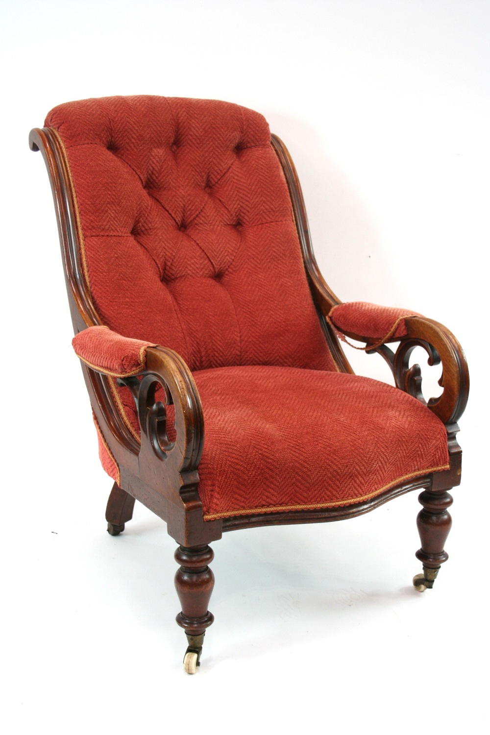 A Victorian mahogany framed armchair, with shaped button back, scrolled arms,