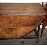 An Antique oak gate leg dining table, having rounded drop leaves,