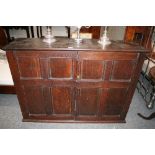 An antique oak cupboard,  the interior shelf enclosed by a pair of  quarter panelled doors,