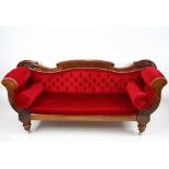 An early Victorian scroll end couch, with red velour upholstery, raised on turned supports,