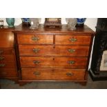 A Georgian oak and mahogany chest, of two short and three long graduated drawers,