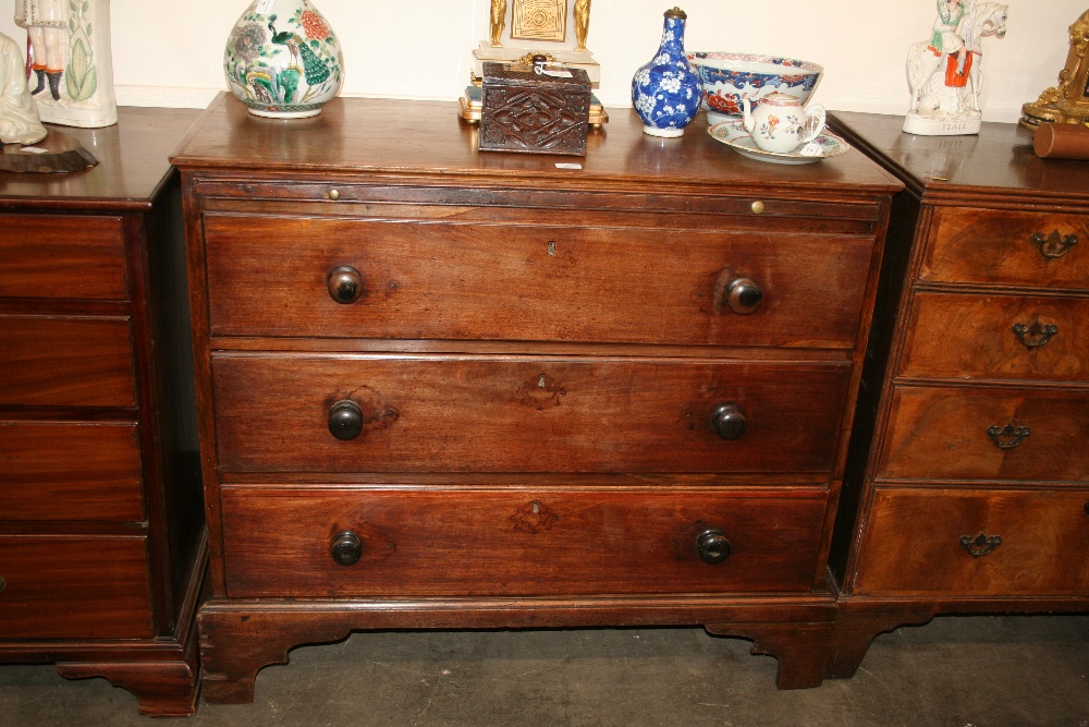 A 19th Century mahogany chest, fitted brushing slide and three long drawers, raised on bracket feet,