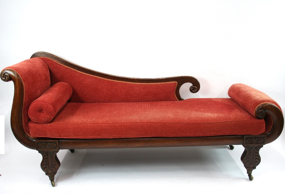 An early 19th Century mahogany chaise longue, with scrolled ends, upholstered in pink velour,