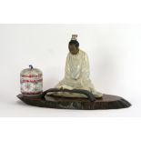 A modern Chinese porcelain figure of a seated scholar reading a book,
