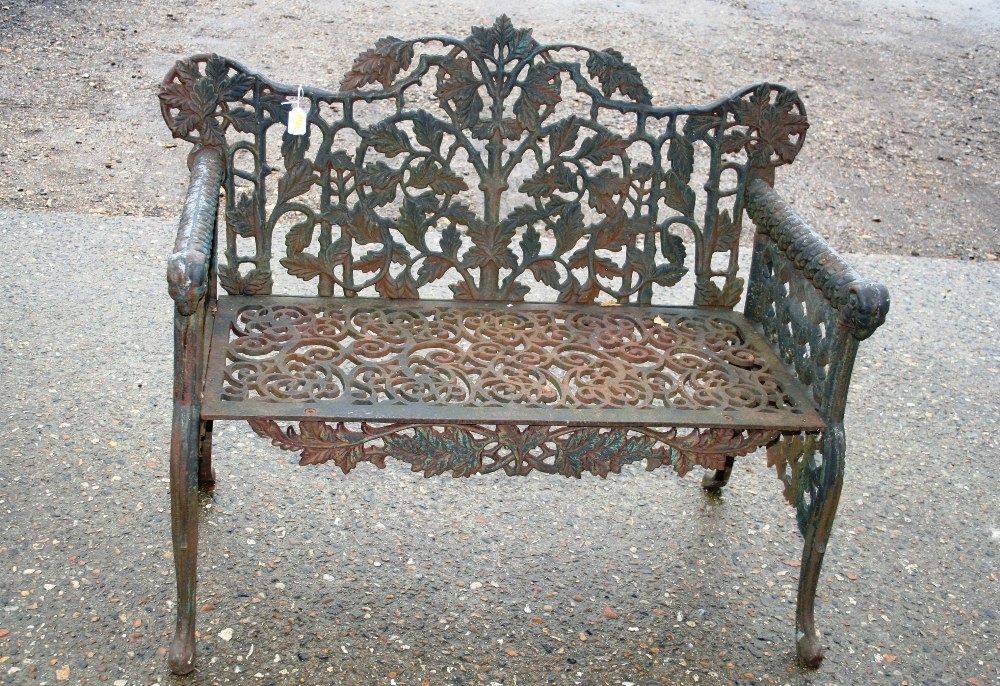 A cast iron garden bench, having profuse pierced leaf decoration,