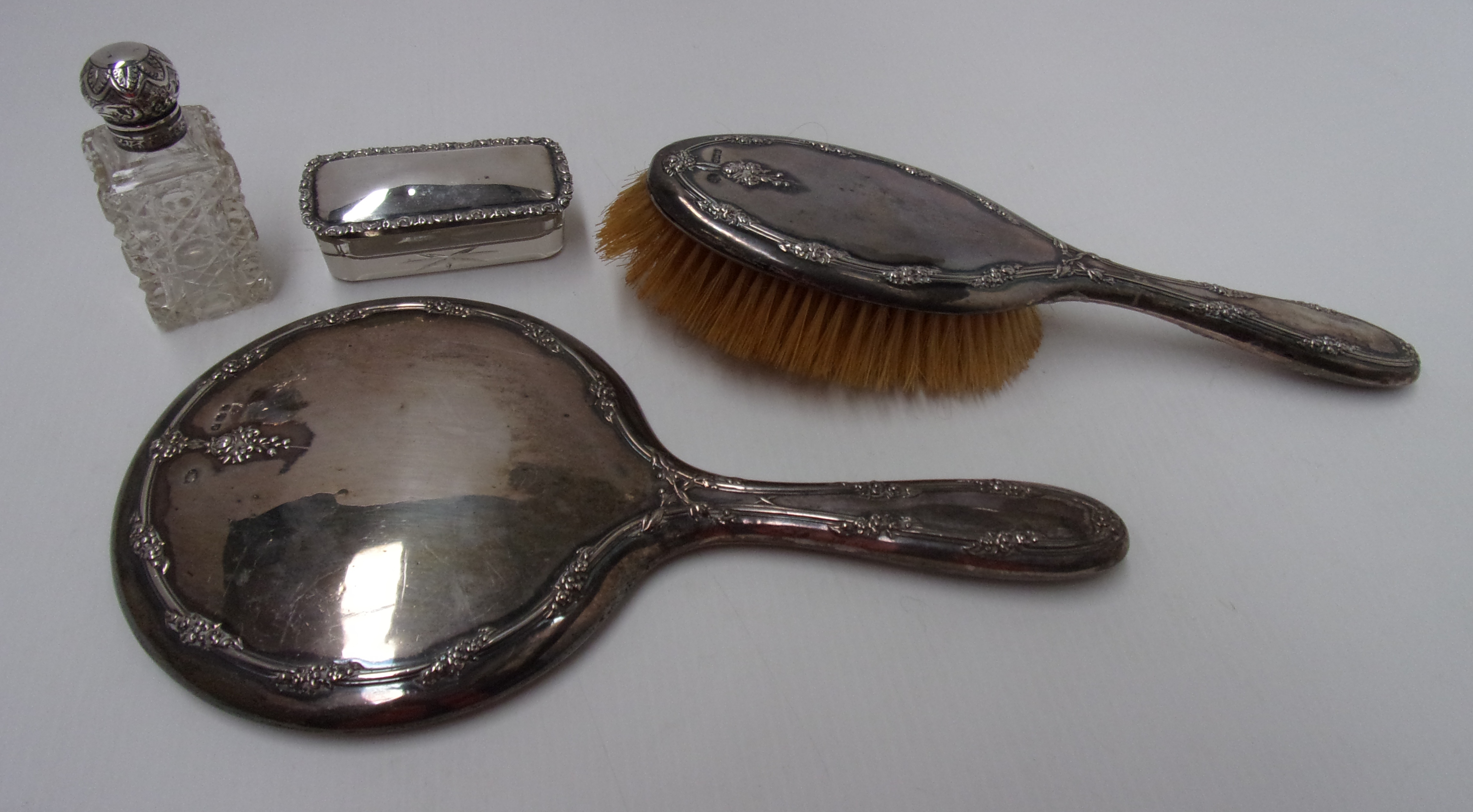 A silver backed hand mirror and brush wi