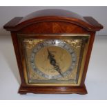 A mantel timepiece in an arched mahogany