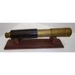 A brass telescope with retractable sun shield and leather cover and a pair of  Prinz 16 x 50