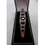 A gold (tests as 9ct) bangle set with se