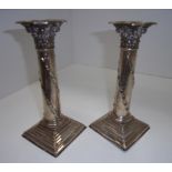A pair of silver classical column candlesticks with acanthus capitals, flower swags and on stepped