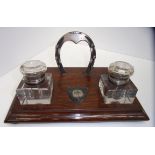 An oak desk stand with two glass ink wel