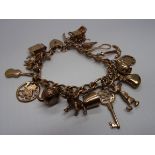 A 9ct gold fancy curb link bracelet hung with charms. Further Information Approx 50g/1.7oz