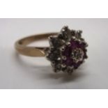 A ruby and diamond cluster ring in 9ct gold flower setting [total approximate weight 3.3g].