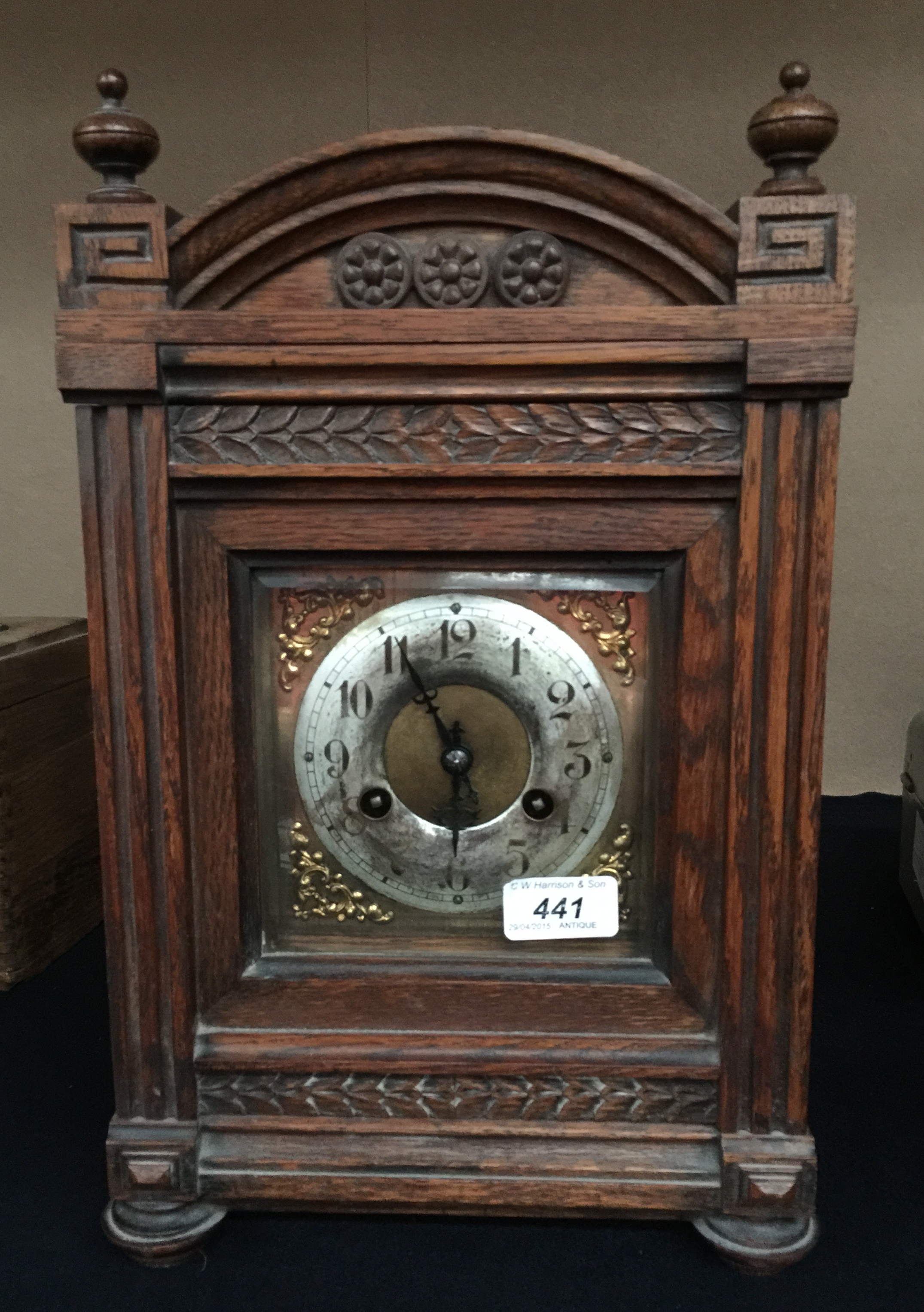 An oak cased mantel clock with carved ar
