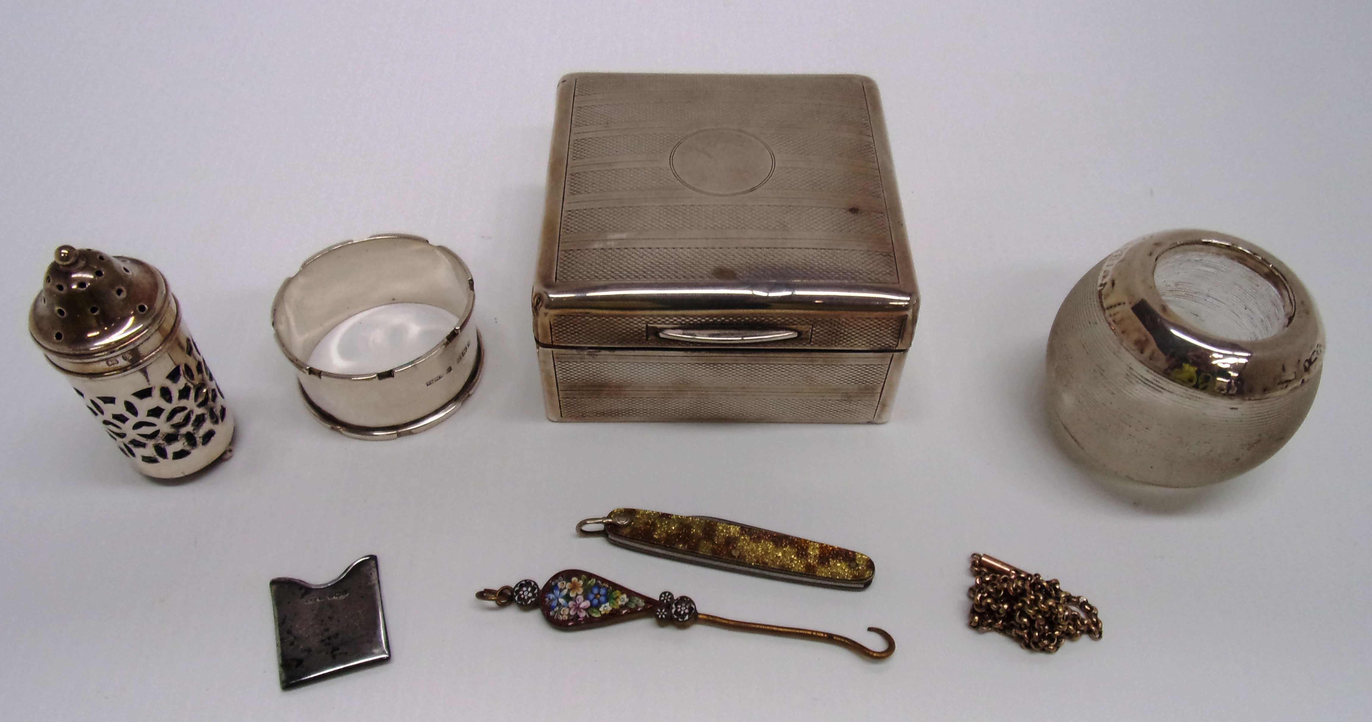 A silver cigarette box with engine turne