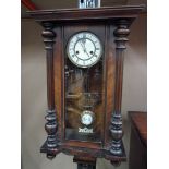 A Victorian wall clock in a glazed walnu