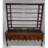 An early 18th century oak dresser with two mahogany banded drawers over a shaped apron and on turned